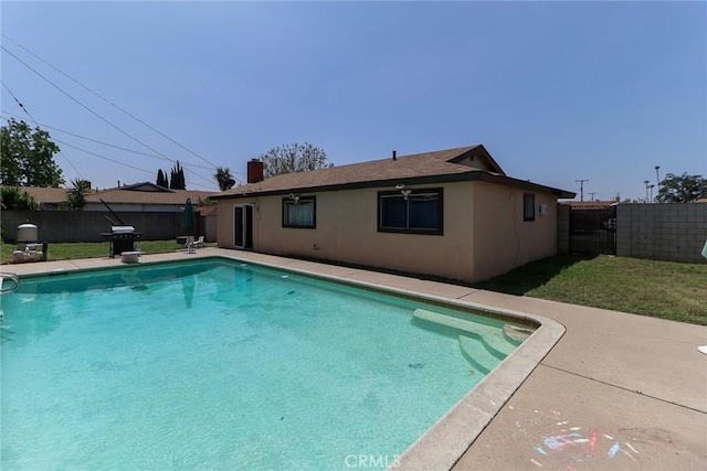 view of swimming pool with a grill, a fenced backyard, and a patio area
