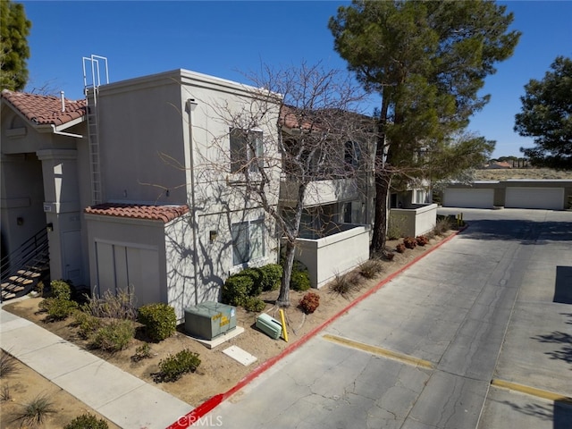 2807 W W Ave K12, Unit 256, Lancaster, CA 93536 - view of front of house featuring stucco siding, a tile roof, and stairway