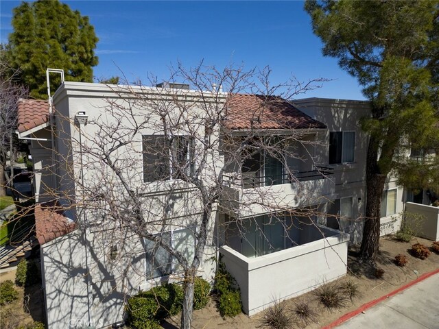 2807 W W Ave K12, Unit 256, Lancaster, CA 93536 - view of property exterior with a tiled roof, a balcony, and fence
