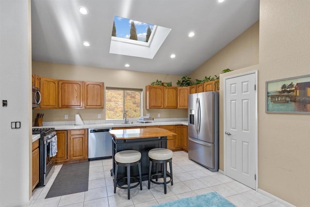 13311 Hillstar Ln, Valley Center, CA 92082 - kitchen with stainless steel appliances, vaulted ceiling, a center island, a sink, and a skylight
