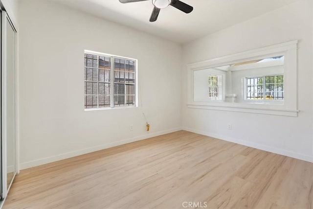 unfurnished room featuring wood finished floors, baseboards, and ceiling fan
