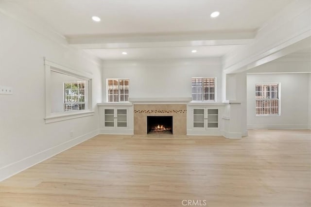 unfurnished living room with light wood finished floors, a fireplace with flush hearth, baseboards, and recessed lighting