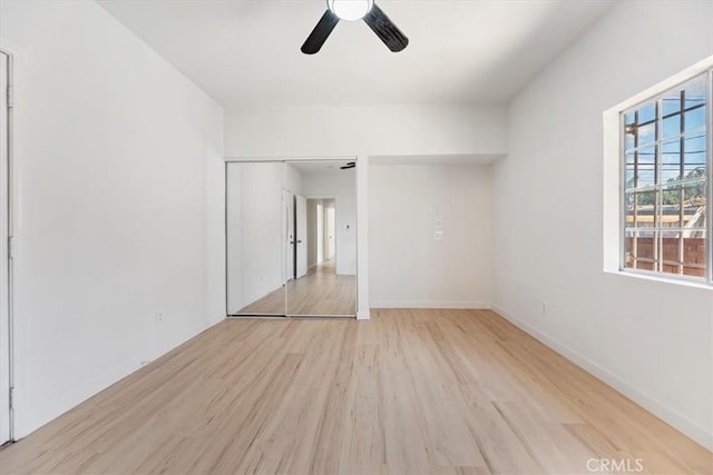 unfurnished room with wood finished floors, ceiling fan, and baseboards