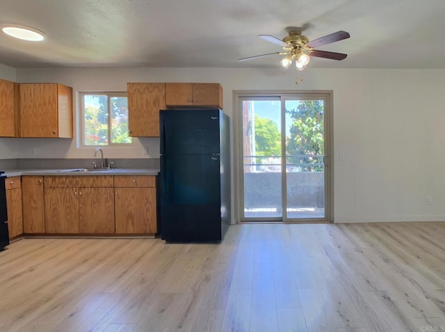 540 65th St Unit 203, San Diego, CA 92114 - kitchen with freestanding refrigerator, a sink, light wood-style flooring, a ceiling fan, and brown cabinets