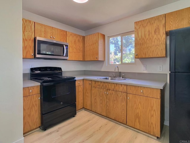 540 65th St Unit 203, San Diego, CA 92114 - kitchen with black appliances, a sink, light wood-style floors, and light countertops