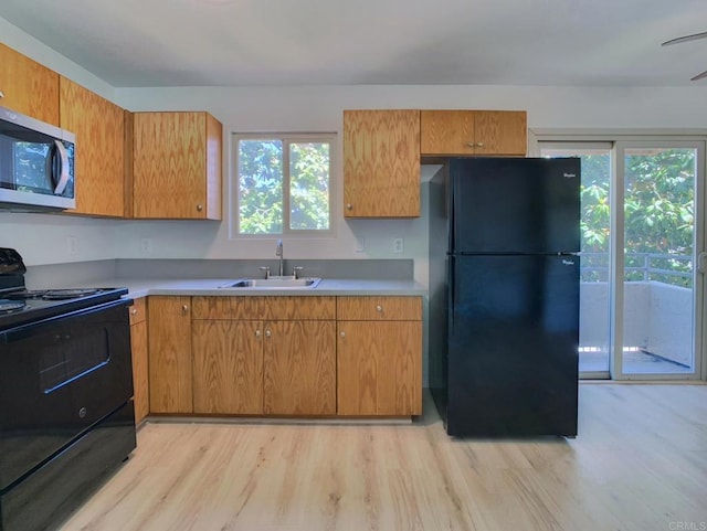 540 65th St Unit 203, San Diego, CA 92114 - kitchen with black appliances, a sink, light wood-style flooring, and light countertops