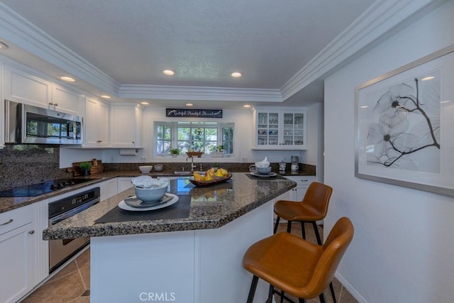 1448 W Domingo Rd, Fullerton, CA 92833 - kitchen with stainless steel appliances, white cabinetry, a breakfast bar, a sink, and ornamental molding