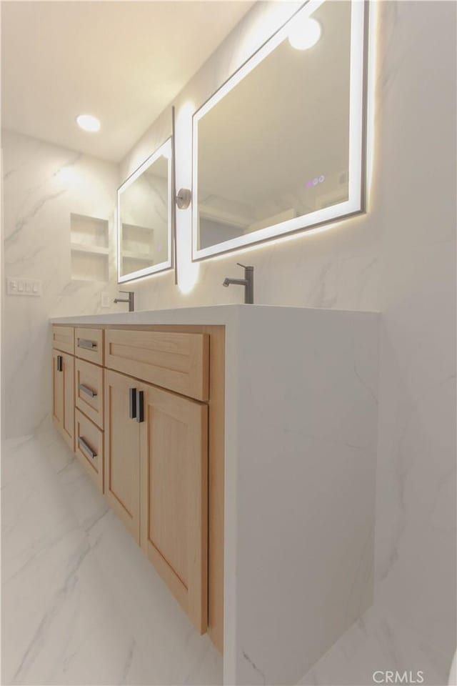 full bath with vanity and marble finish floors