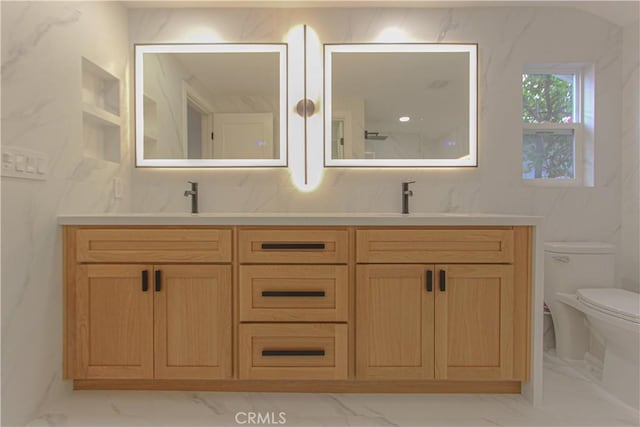 bathroom with marble finish floors, toilet, double vanity, and tasteful backsplash
