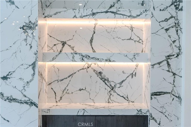 bathroom view of a marble finish shower