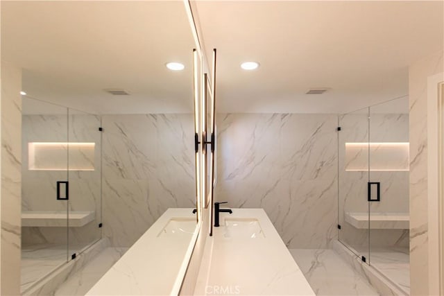 bathroom with marble tiled flooring, recessed lighting, a marble finish shower, tile walls, and vanity