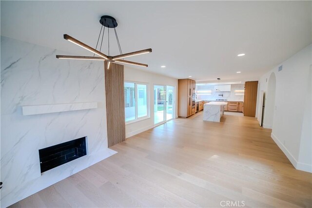 24701 Sarah Ln, Lake Forest, CA 92630 - unfurnished living room with a premium fireplace, light wood finished floors, recessed lighting, arched walkways, and baseboards
