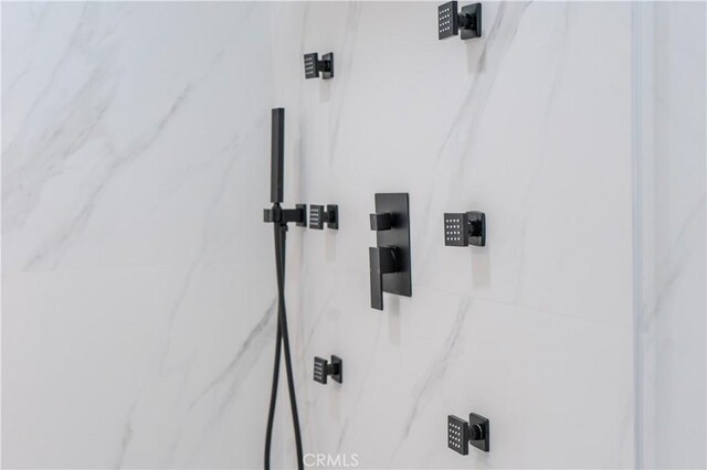 bathroom view of a marble finish shower