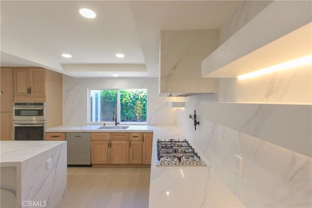 kitchen featuring appliances with stainless steel finishes, a sink, tasteful backsplash, light stone counters, and recessed lighting