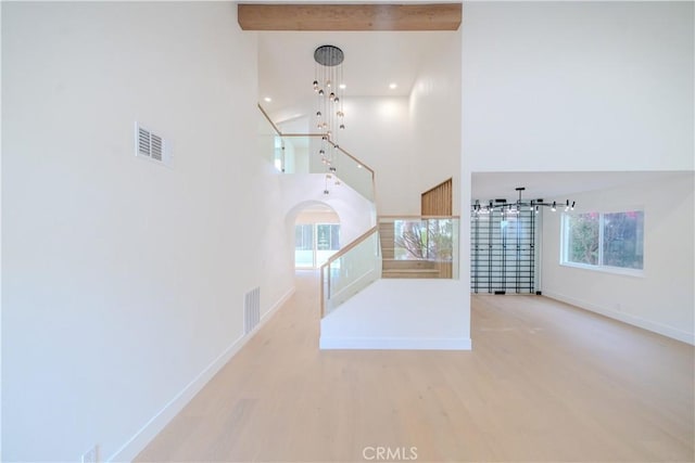 staircase featuring a high ceiling, baseboards, wood finished floors, healthy amount of natural light, and recessed lighting