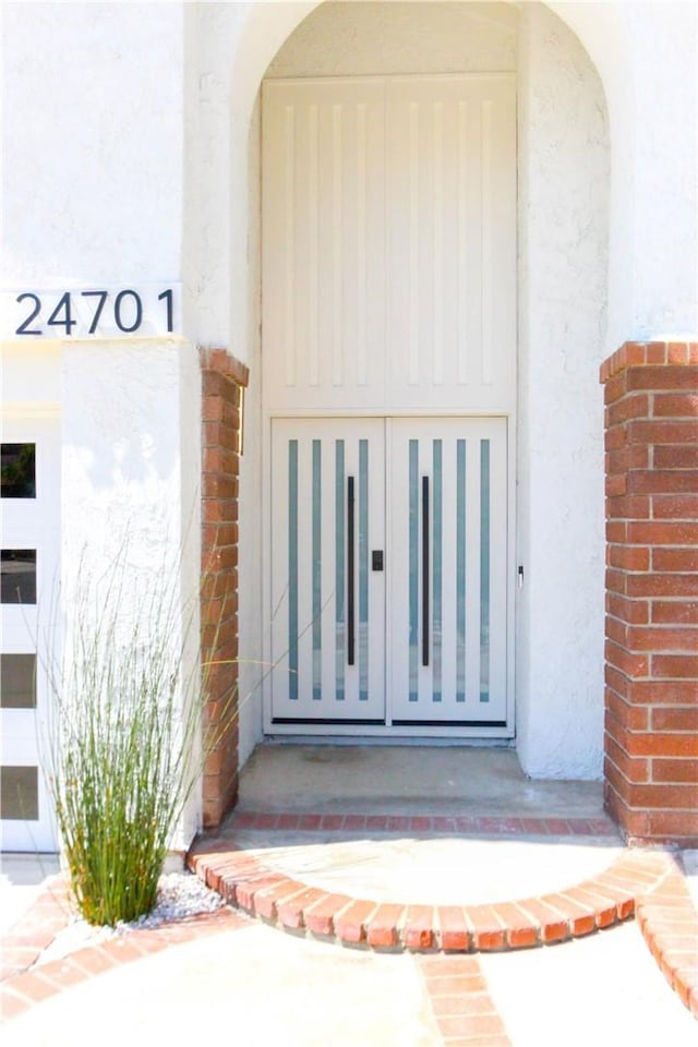doorway to property featuring stucco siding