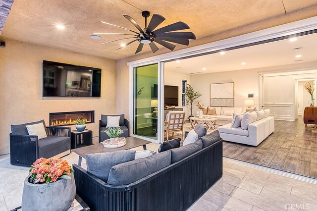 47 Cielo Azul, Mission Viejo, CA 92692 - tiled living room with a glass covered fireplace, ceiling fan, recessed lighting, and a textured ceiling