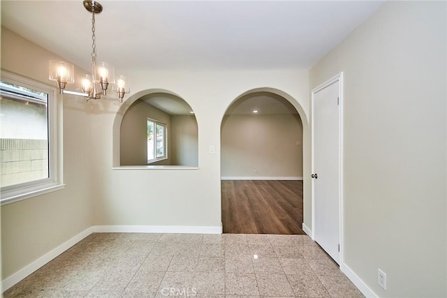 17721 Alexander Pl, Cerritos, CA 90703 - spare room with baseboards, a chandelier, granite floors, and arched walkways