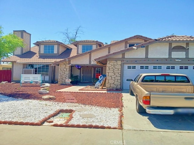 view of front of house featuring stone siding, an attached garage, stucco siding, and driveway