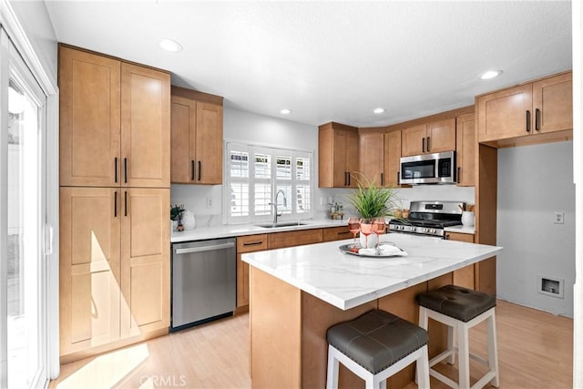 2 Chestnut Dr, Aliso Viejo, CA 92656 - kitchen featuring stainless steel appliances, a sink, light wood finished floors, a breakfast bar area, and recessed lighting