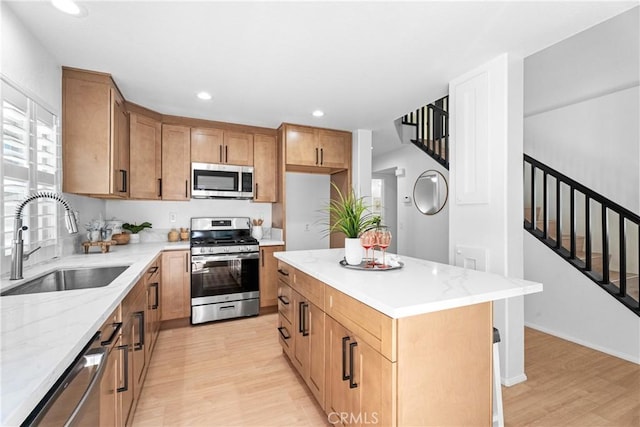 2 Chestnut Dr, Aliso Viejo, CA 92656 - kitchen featuring appliances with stainless steel finishes, a sink, light wood-type flooring, light stone countertops, and brown cabinetry