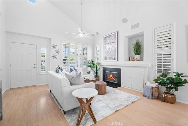 2 Chestnut Dr, Aliso Viejo, CA 92656 - living room featuring light wood-style floors, a fireplace with flush hearth, a high ceiling, a ceiling fan, and baseboards