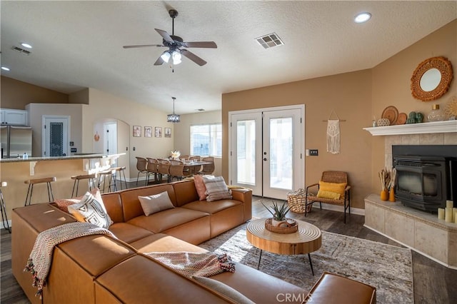 6366 Murrieta Ave, Yucca Valley, CA 92284 - living room featuring dark wood finished floors, a wood stove, lofted ceiling, french doors, and a ceiling fan