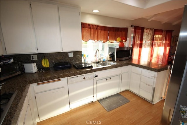 2026 Mirasol, North Tustin, CA 92705 - kitchen featuring appliances with stainless steel finishes, a sink, light wood-style floors, tasteful backsplash, and white cabinetry