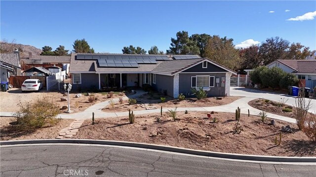 16395 Cuyama Way, Apple Valley, CA 92307 - ranch-style house with roof mounted solar panels, fence, concrete driveway, and stucco siding