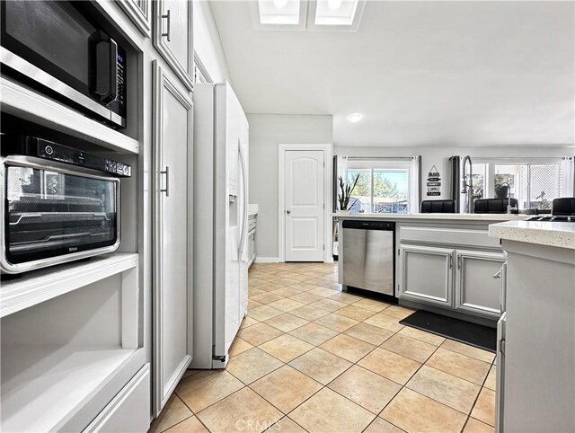 16395 Cuyama Way, Apple Valley, CA 92307 - kitchen featuring stainless steel appliances, light countertops, gray cabinets, light tile patterned floors, and baseboards