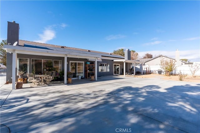 16395 Cuyama Way, Apple Valley, CA 92307 - back of house featuring solar panels, a chimney, and a patio area