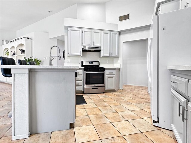 16395 Cuyama Way, Apple Valley, CA 92307 - kitchen with gas range, freestanding refrigerator, a sink, light countertops, and under cabinet range hood