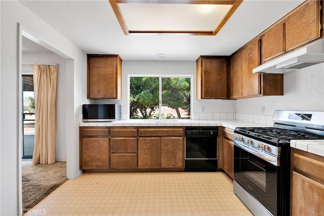 7621 Alston Ave, Hesperia, CA 92345 - kitchen featuring stainless steel appliances, under cabinet range hood, brown cabinets, tile counters, and light floors