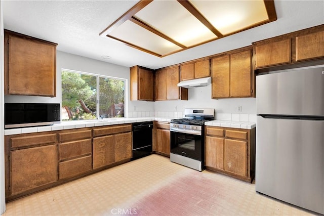 7621 Alston Ave, Hesperia, CA 92345 - kitchen featuring stainless steel appliances, under cabinet range hood, brown cabinetry, and light floors
