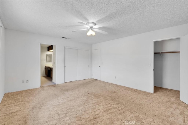 7621 Alston Ave, Hesperia, CA 92345 - unfurnished bedroom featuring carpet flooring, ensuite bath, a textured ceiling, multiple closets, and ceiling fan