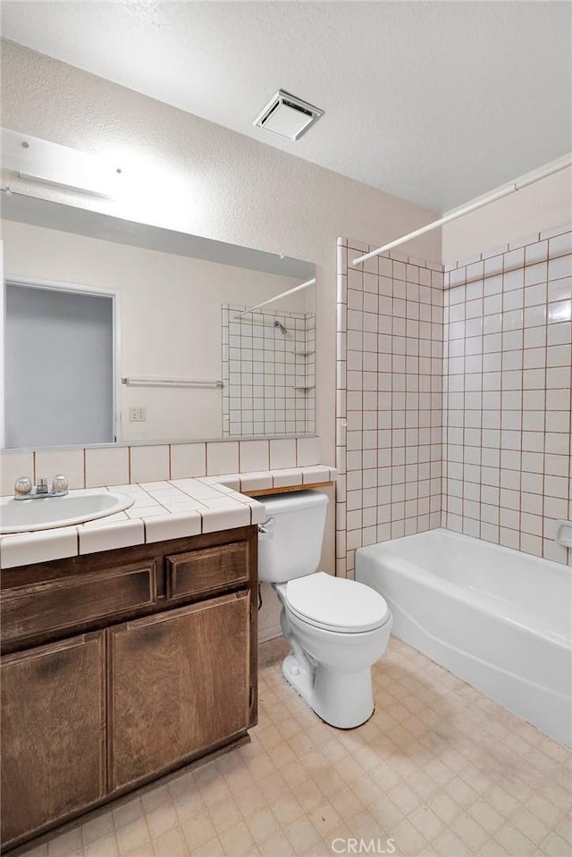 7621 Alston Ave, Hesperia, CA 92345 - bathroom featuring vanity, toilet, shower / bath combination, tile patterned floors, and a textured ceiling