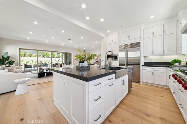 56 Chasma, Irvine, CA 92618 - kitchen with stainless steel appliances, dark countertops, a sink, white cabinets, and recessed lighting