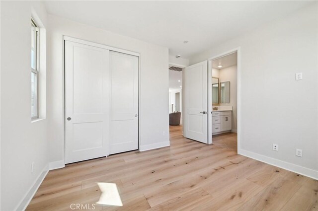56 Chasma, Irvine, CA 92618 - unfurnished bedroom featuring light wood-style floors, baseboards, a closet, and connected bathroom