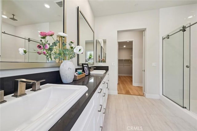 56 Chasma, Irvine, CA 92618 - bathroom featuring a shower stall, baseboards, double vanity, and recessed lighting