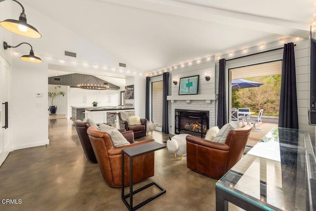 living room featuring finished concrete floors, a fireplace, baseboards, and high vaulted ceiling
