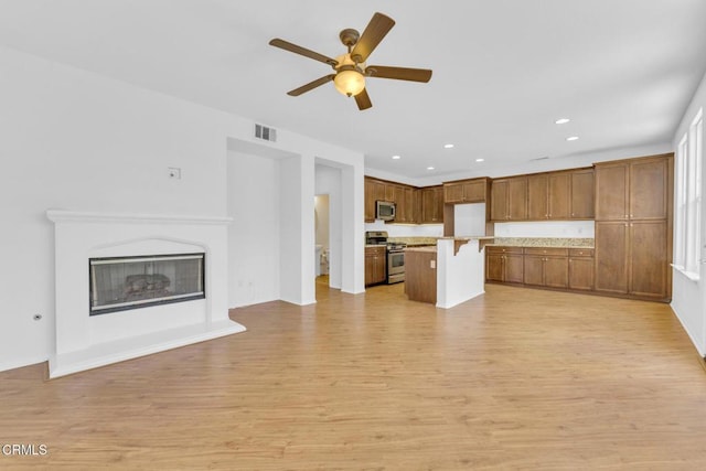 40197 Gallatin Ct, Temecula, CA 92591 - unfurnished living room featuring light wood-style flooring, ceiling fan, recessed lighting, a glass covered fireplace, and baseboards