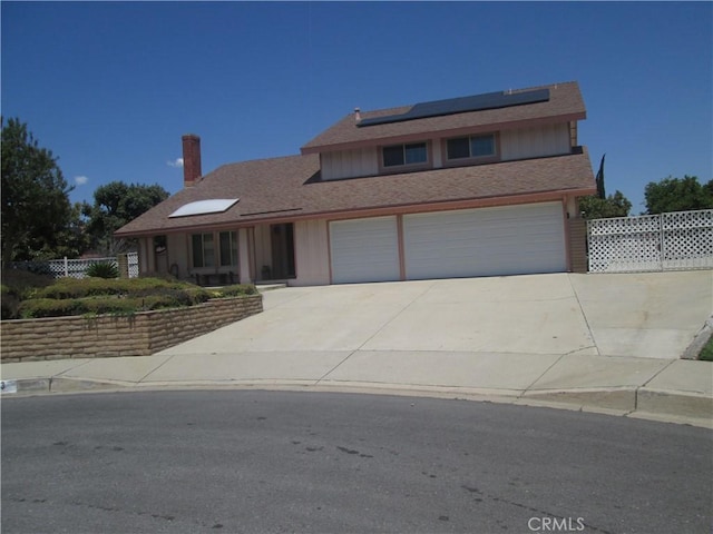 11133 Shetland Ave, Montclair, CA 91763 - traditional home featuring driveway, solar panels, a chimney, a garage, and board and batten siding