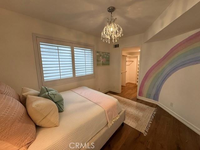 854 Cypress Ave, Hermosa Beach, CA 90254 - bedroom with a chandelier, baseboards, wood finished floors, and a spacious closet
