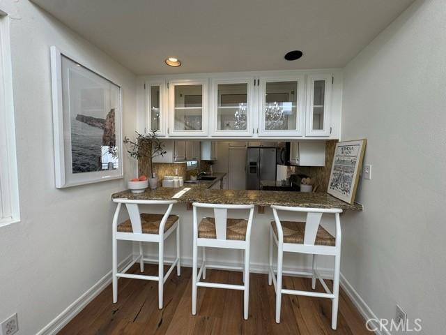 854 Cypress Ave, Hermosa Beach, CA 90254 - kitchen with stainless steel fridge with ice dispenser, wood finished floors, baseboards, glass insert cabinets, and recessed lighting