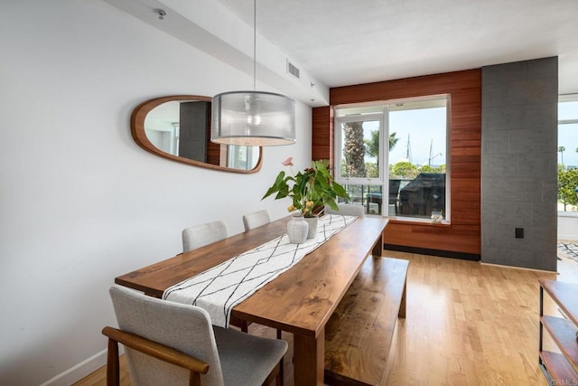 dining room with light wood-type flooring, plenty of natural light, and baseboards
