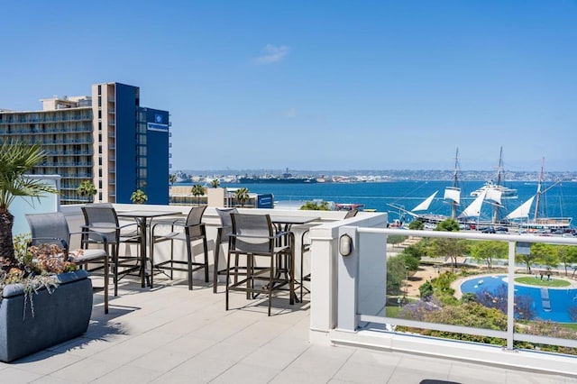 view of patio featuring a water view and a bar