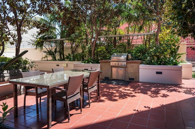 view of patio featuring area for grilling, exterior kitchen, fence, and outdoor dining space