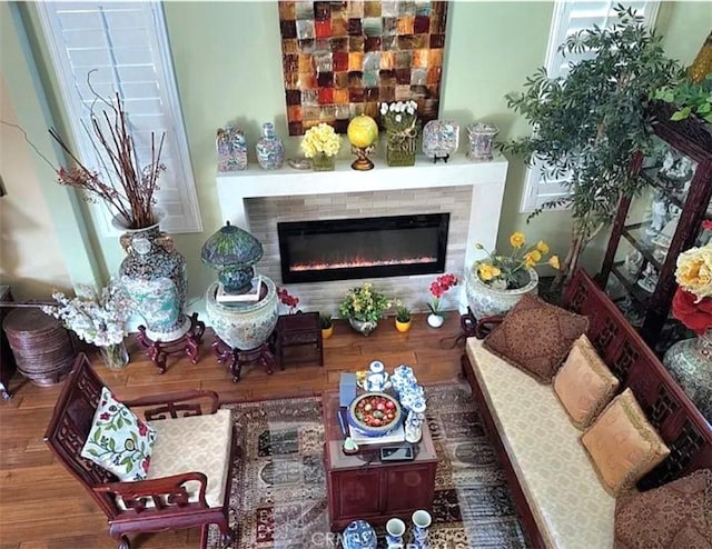 living room with a glass covered fireplace and wood finished floors
