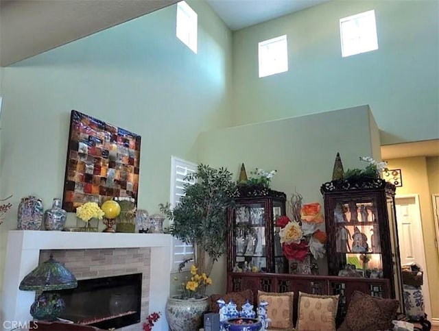 living room with a towering ceiling and a brick fireplace