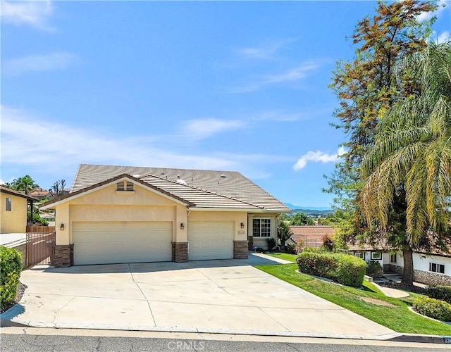 23651 Cruise Circle Dr, Canyon Lake, CA 92587 - view of front of home featuring stucco siding, concrete driveway, an attached garage, and stone siding